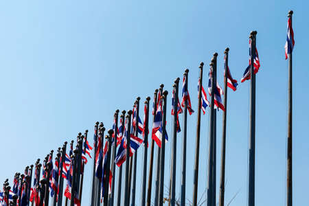 Numerous flags of thailand on blue sky background.