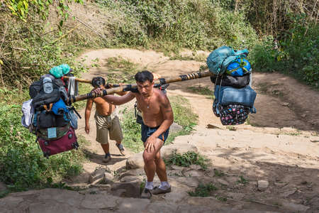 Loei, Thailand - December 24, 2018: Sherpas are carrying a lot of baggage of tourists on his...