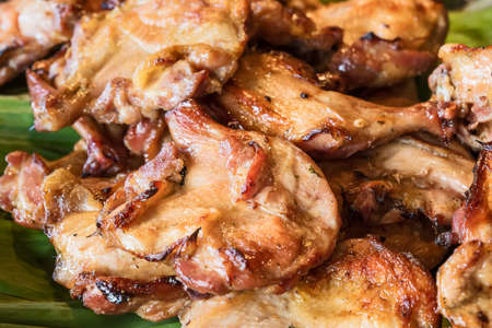 Grilled chicken hips , crispy, placed on banana leaves, ready to eat.