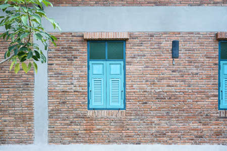 Blue windows on the old brown brick wall in vintage style.の写真素材