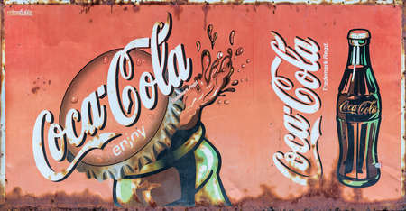 Bangkok, Thailand - August 18, 2019: Grunge rusty retro vintage Coca-Cola advertising metal board sign.のeditorial素材