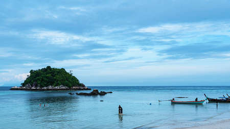 Koh Lipe, Andaman Sea, Thailand, 18 September 2019: Tourists take a walk along the beach and swim at Koh Lipe, beautiful beaches and sea. There is a long tail boat of fishermen at Koh Lipe, Thailand.の写真素材