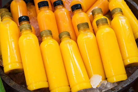 Fresh orange juice packaged in bottles ready for sale.の写真素材