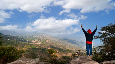 man on top of a mountain feeling of freedom relaxed air ozone nature, on vacation days.