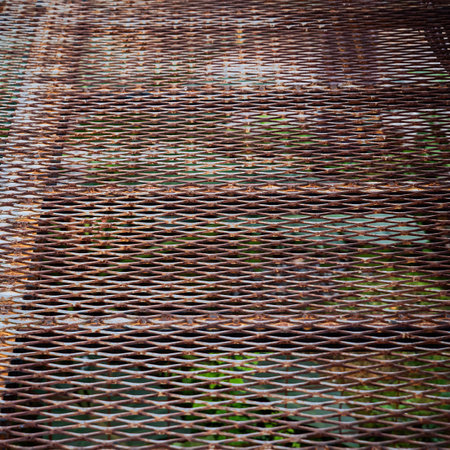 A metal grid background was used to create a high-altitude walking grate as it was lighter than concrete and was visible below. Full frame metal grid backgrounds are perfect for design projects.の写真素材