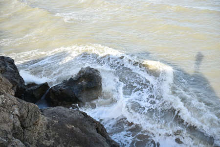 winter beach in a storm with muddy surf of big waves