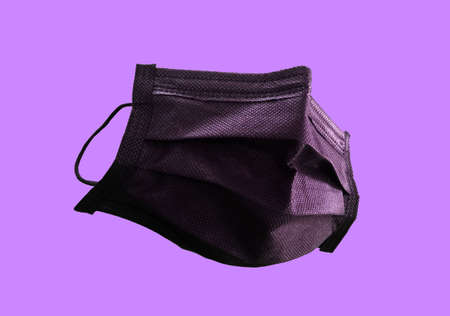 Single black medical mask isolated on purple background, Equipment is use to protective coronavirus, Medical, Close upの写真素材