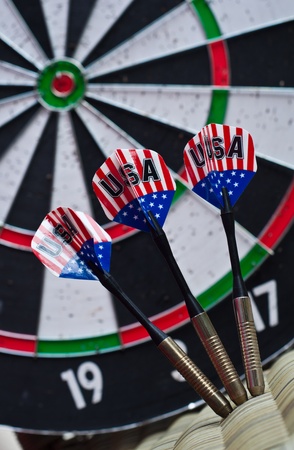 3 darts with dartboard backgroundの写真素材