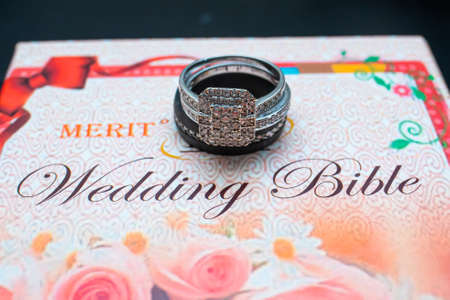 a red wedding bible with a wedding ringの写真素材
