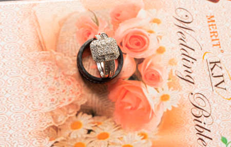 a red wedding bible with a wedding ringの写真素材