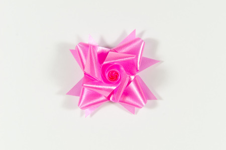 pink flower made from ribbon on white の写真素材