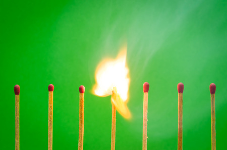 burnning match setting on green background for ideas and inspirationの写真素材