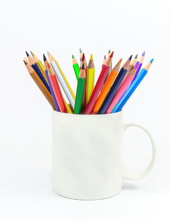 The colored pencils are in a cup on white backgroundの写真素材