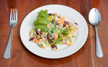 The food salad in plate is on wood background.の写真素材