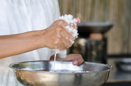 asian woman is making coconut milk for cookingの写真素材