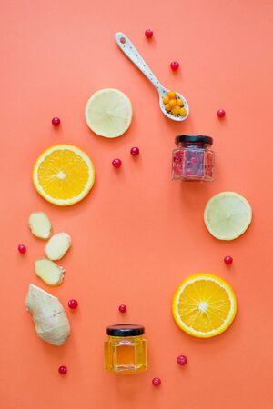 Citrus fruits, ginger, honey and cranberries on the orange background. Health and tasty food to boost immune systemの写真素材