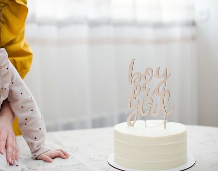 White "Boy or girl" cake for gender reveal party with wooden topperの写真素材