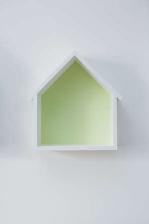 Empty house shaped shelf on a white wall. Decoration in kids roomの写真素材
