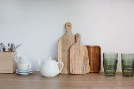 Kitchen utensils on light wooden kitchen interior. Cooking tableware on a white background