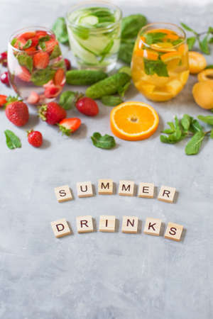 Fresh summer fruit cocktails. Set of summer drinks on gray concrete background. Mocktails with strawberry, cherry, cucumber, basil, apricot, orange and mintの写真素材