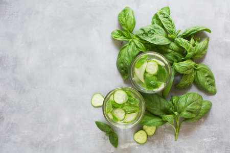 Fresh summer green vegetable cocktail. Mocktail with basil leaves anf cucumber. Green fresh drink on a gray backgroundの写真素材
