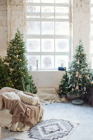 White living room with fireplace, Christmas trees and Christmas decorationsの写真素材