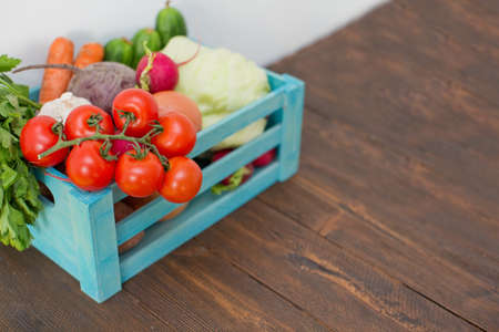 Fresh vegetables in a blue wooden box. Food delivery. Organic eco market