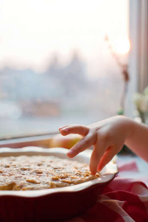 Childs hand touch fresh baked apple pieの写真素材