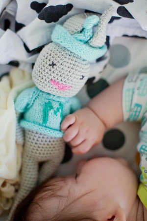 Cute little baby sleep in his crib with bunny toyの写真素材