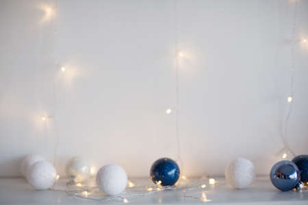 White and blue Christmas balls with Christmas lights on a white backgroundの写真素材