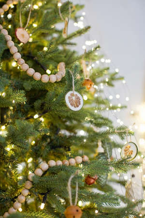 Rustic Christmas tree with handmade decorations. Cozy light interior with Christmas decorations and...