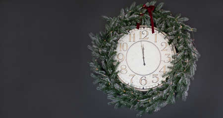 Vintage Christmas clock with frame of Christmas wreath on a black backround. Copy space, place for...