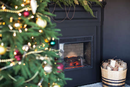 Dark Christmas interior with black fireplace and Christmas treeの写真素材