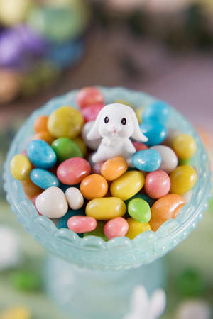 Pastel Easter decorations with bunny, colorful eggs candy on a light colorful backgroundの写真素材