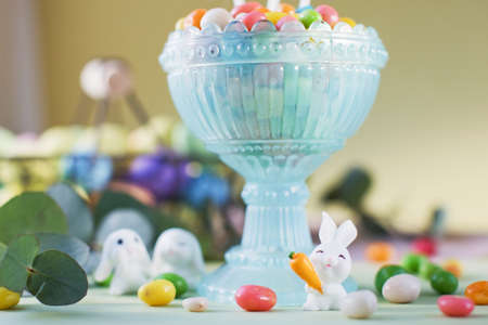 Pastel Easter decorations with bunny, colorful eggs candy on a light colorful background