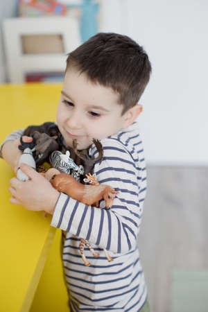 Caucasian toddler boy playing with colorful toy blocks in his room.の写真素材