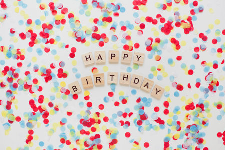 Happy birthday wooden sign on colorful confetti backgroundの写真素材