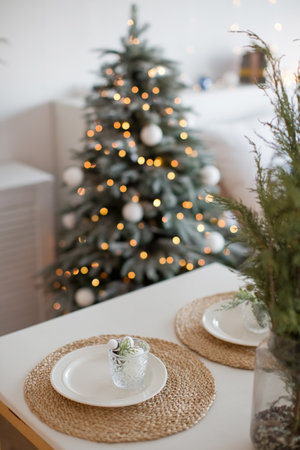 Christmas rustic natural table setting on a backround of Christmas tree with lightsの写真素材