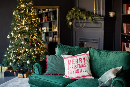 Dark Christmas interior with Christmas tree, fireplace and emerald sofaの写真素材