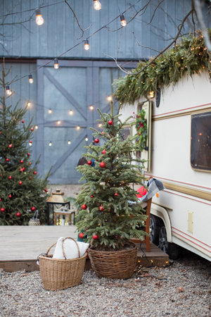 Christmas tree with decorations outdoor near travel trailer. Cozy Christmas outdoor decorationsの写真素材