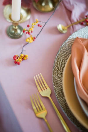 Beautiful table setting with autumn flowers, orange and pink napkins and burning candles. Autumn wedding conceptの写真素材