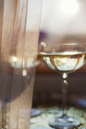 Glass of champagne with golden stars confetti on the silver tray. New year party conceptの写真素材