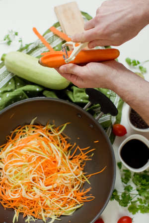 Black wok pan with raw vegetables, making asian vegan dish. Fresh raw vegetables, tasty healthy food