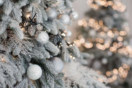 Christmas tree with silver, white decorations and cozy lights. Christmas concept with copy space, place for textの写真素材