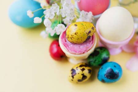 Easter eggs and flowers on a yellow background. Easter background with pastel colors details. spring...