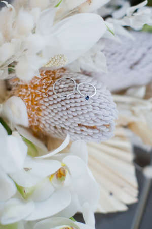 Wedding rings on wedding boho bouquet with banksia,orchids and dry flowersの写真素材