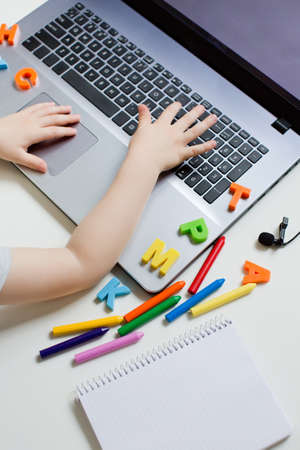 distance education concept. Little caucasian boy in headphones have video call studies online on laptop, homeschooling concept. Kindergarten online studyの写真素材