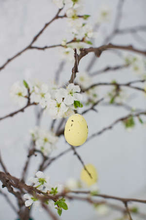 Easter tree in blue vase with colorful eggs on a white background