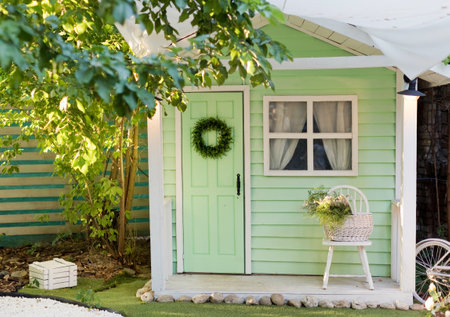 Small green shed garden house with window, door and chair outside. Kids playhouse, garden...