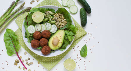 Banner with fresh vegetarian bowl with falafel, avocado, cucumber, asparagus, lime, flax and pumpkin...